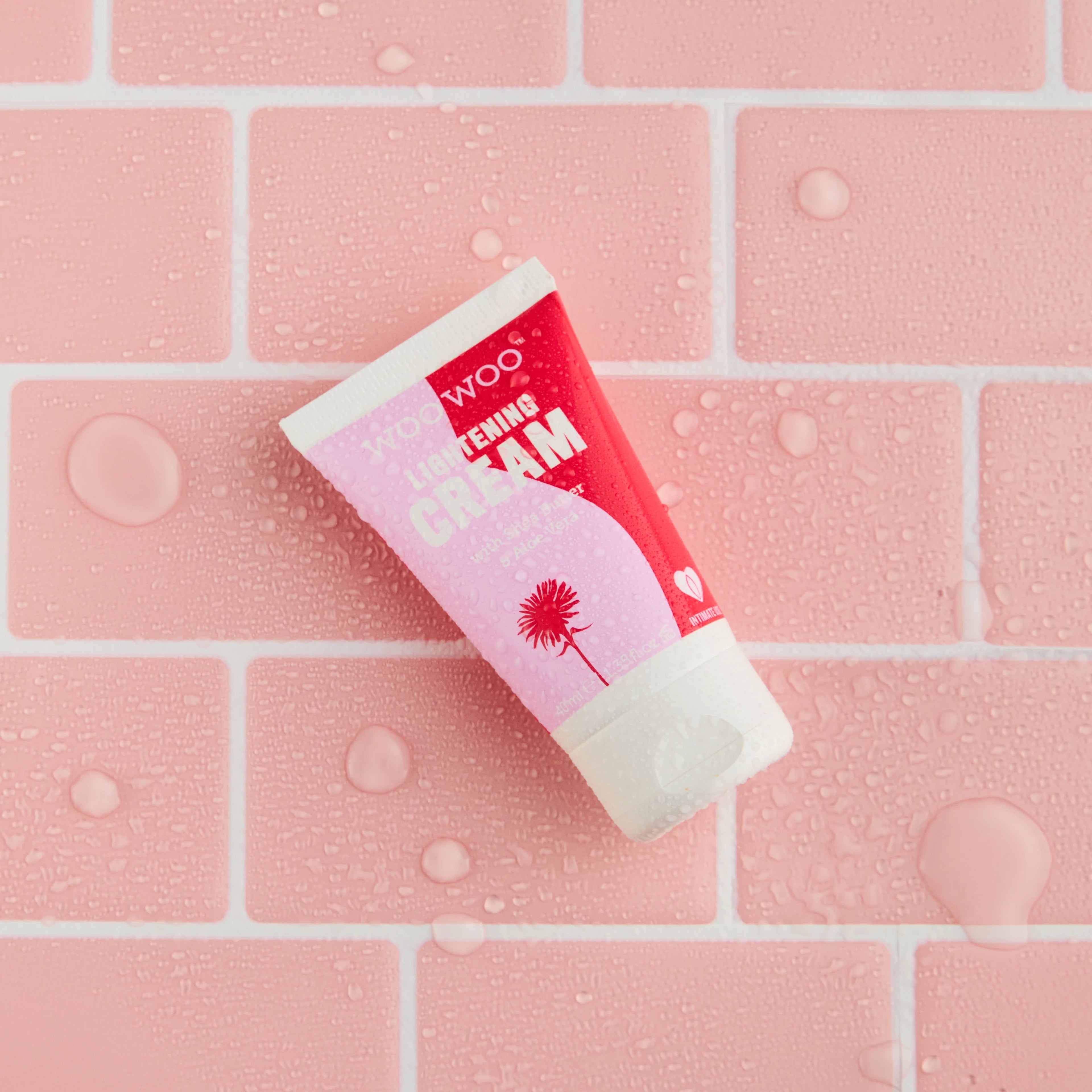 Tube of cream on a pink tiled background