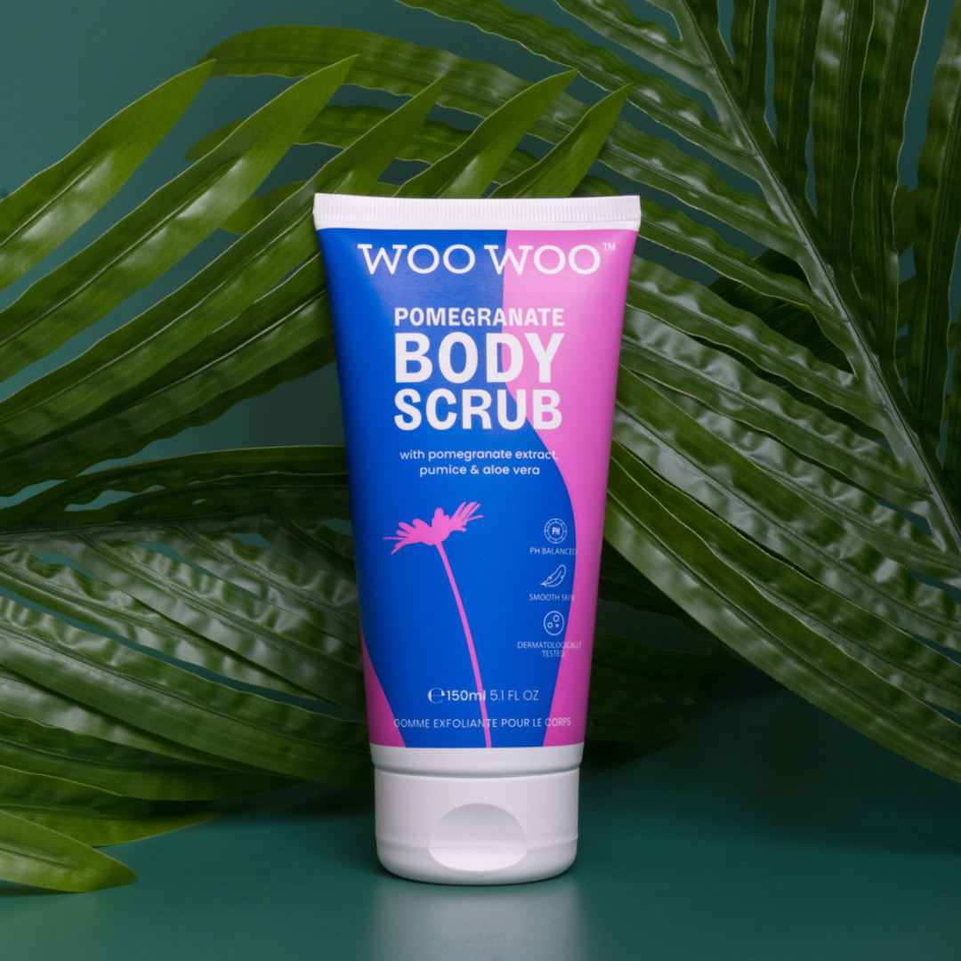 Tube of WooWoo pomegranate scrub with plants in the background