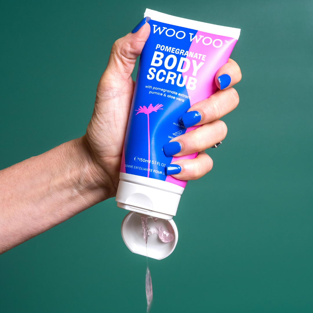 Tube of WooWoo pomegranate body scrub being poured on green background