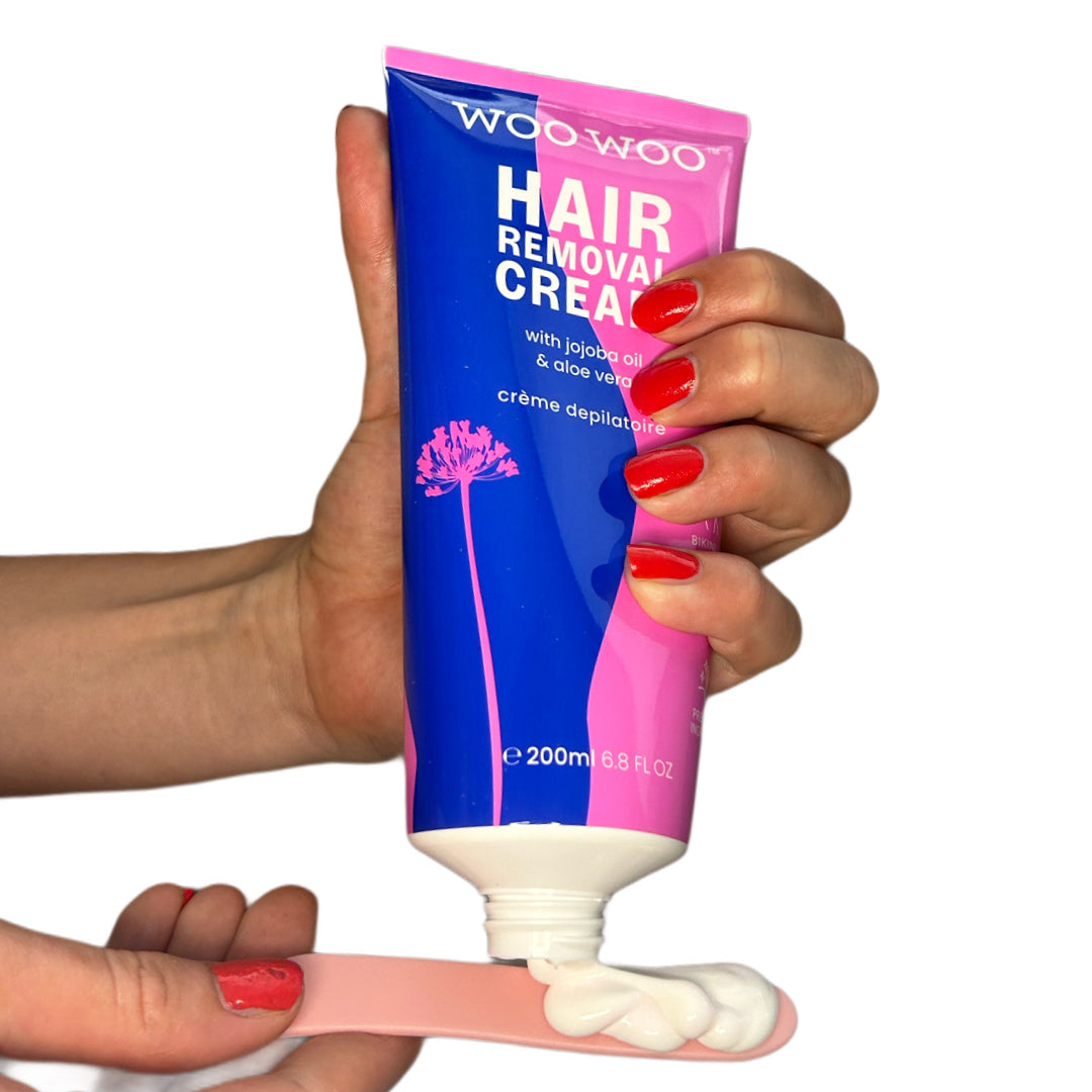 Tube of WooWoo hair removal cream being applied on white background
