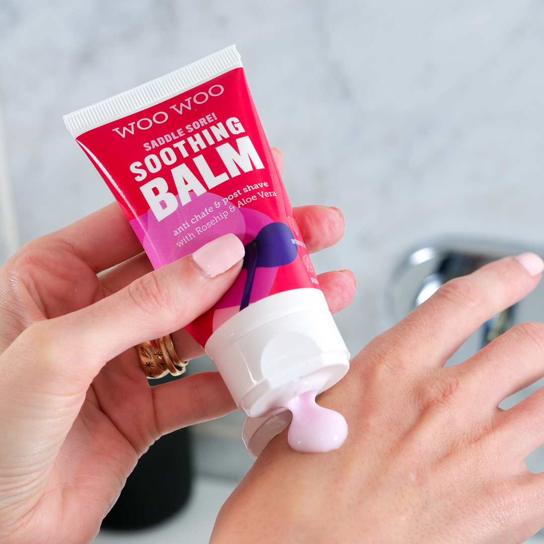 Saddle Sore Soothing Balm being applied to the top of a hand with bathroom background