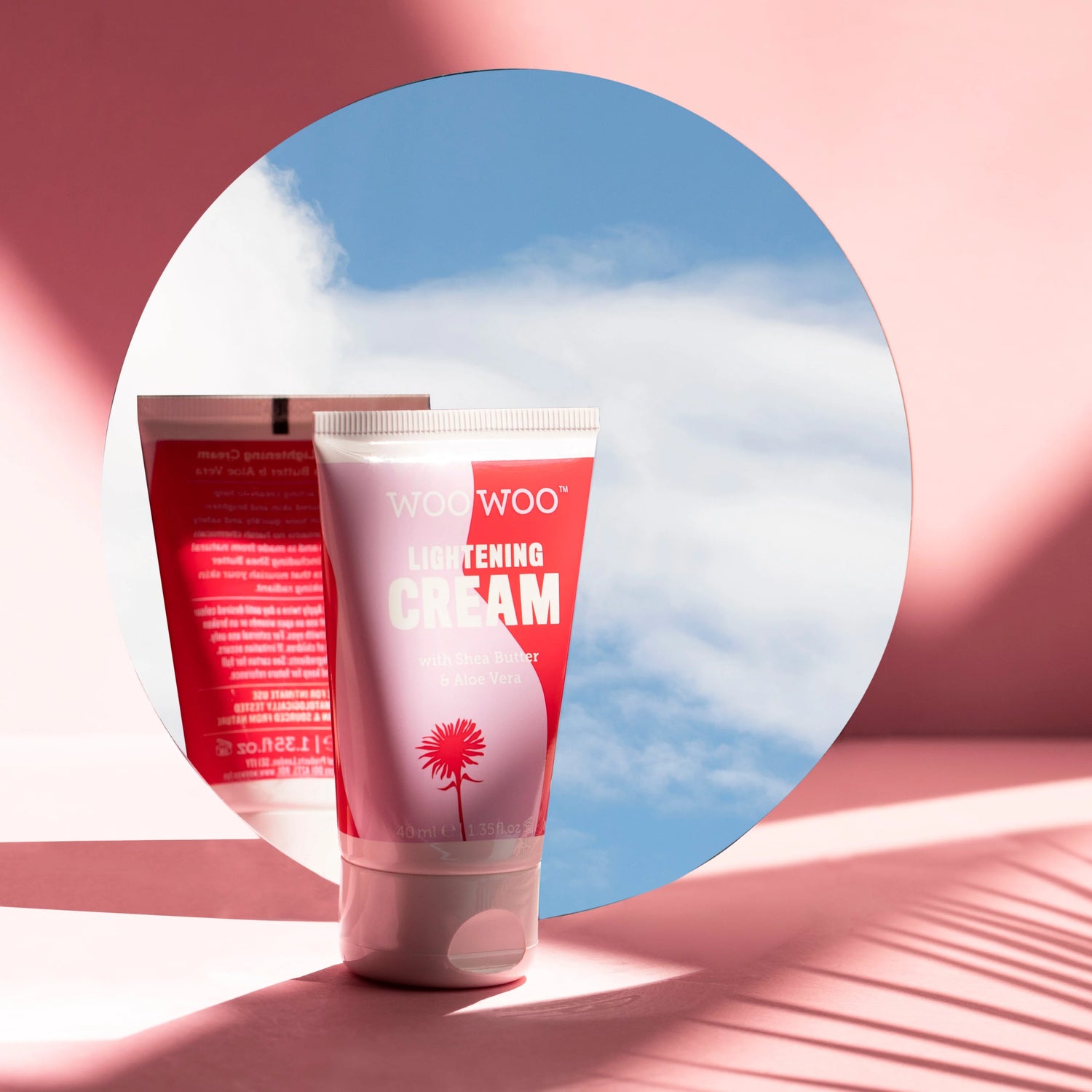 Two tubes of WooWoo Lightening Cream against a pink and blue abstract background