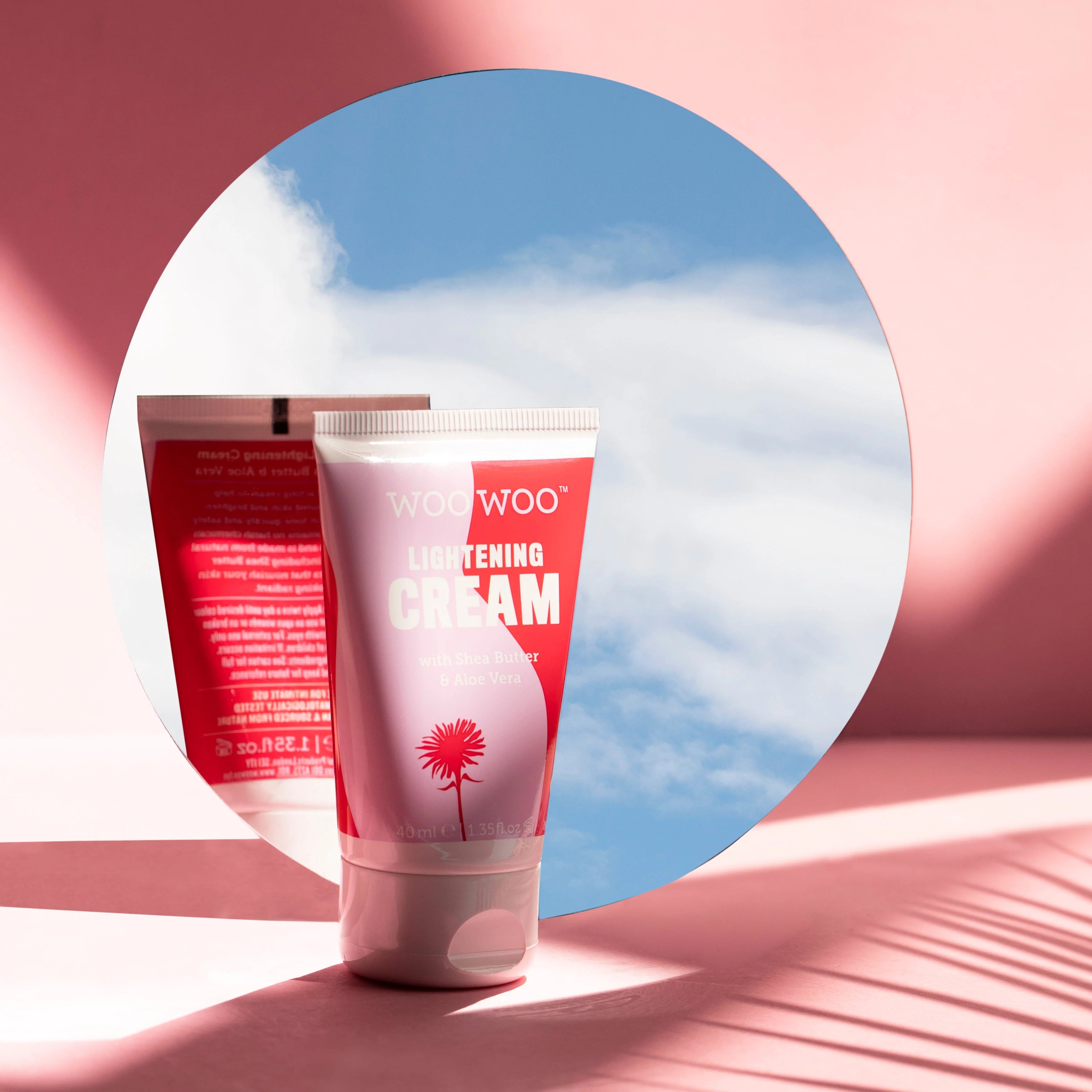 Two tubes of WooWoo Lightening Cream against a pink and blue abstract background
