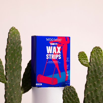 Packet of WooWoo Tame It Wax Strips between cactai and white background